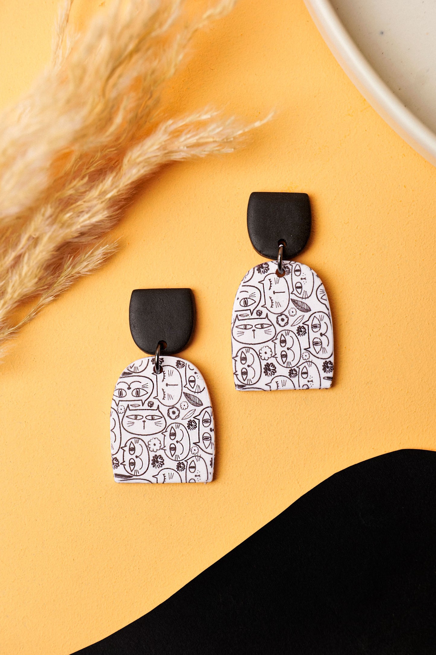 Cat doodle earrings with a bold black stud. A Berlin flea-market kind of cool.
