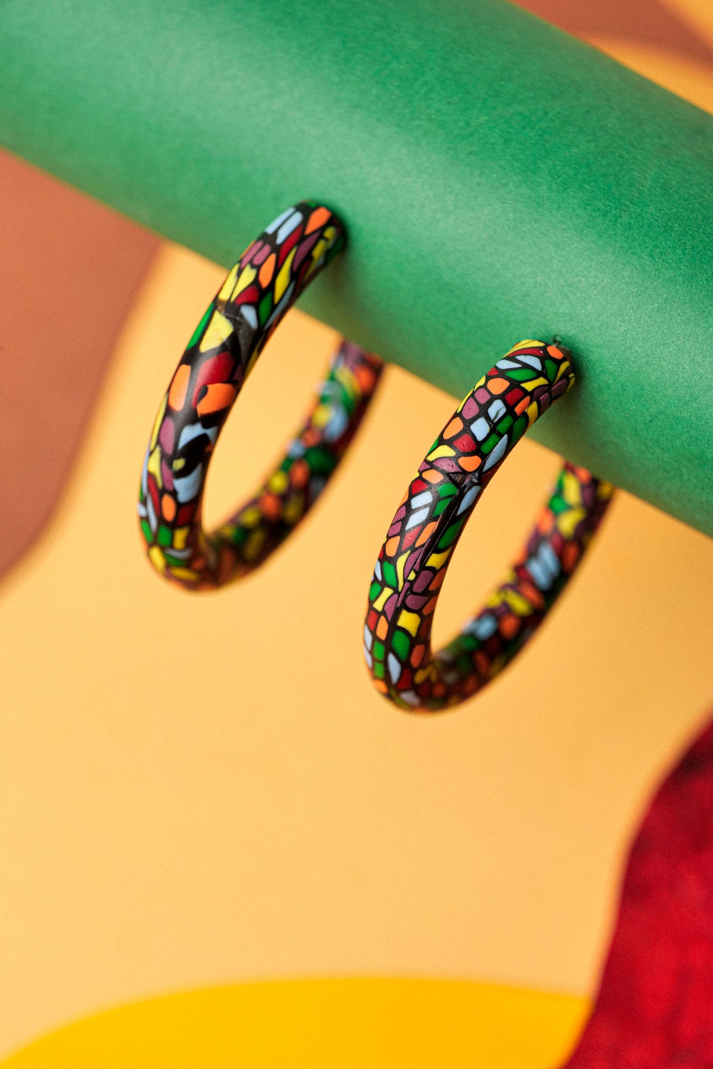 Graphic hoops in black clay with a burst of colour. Bold, lightweight, and handmade in Berlin.