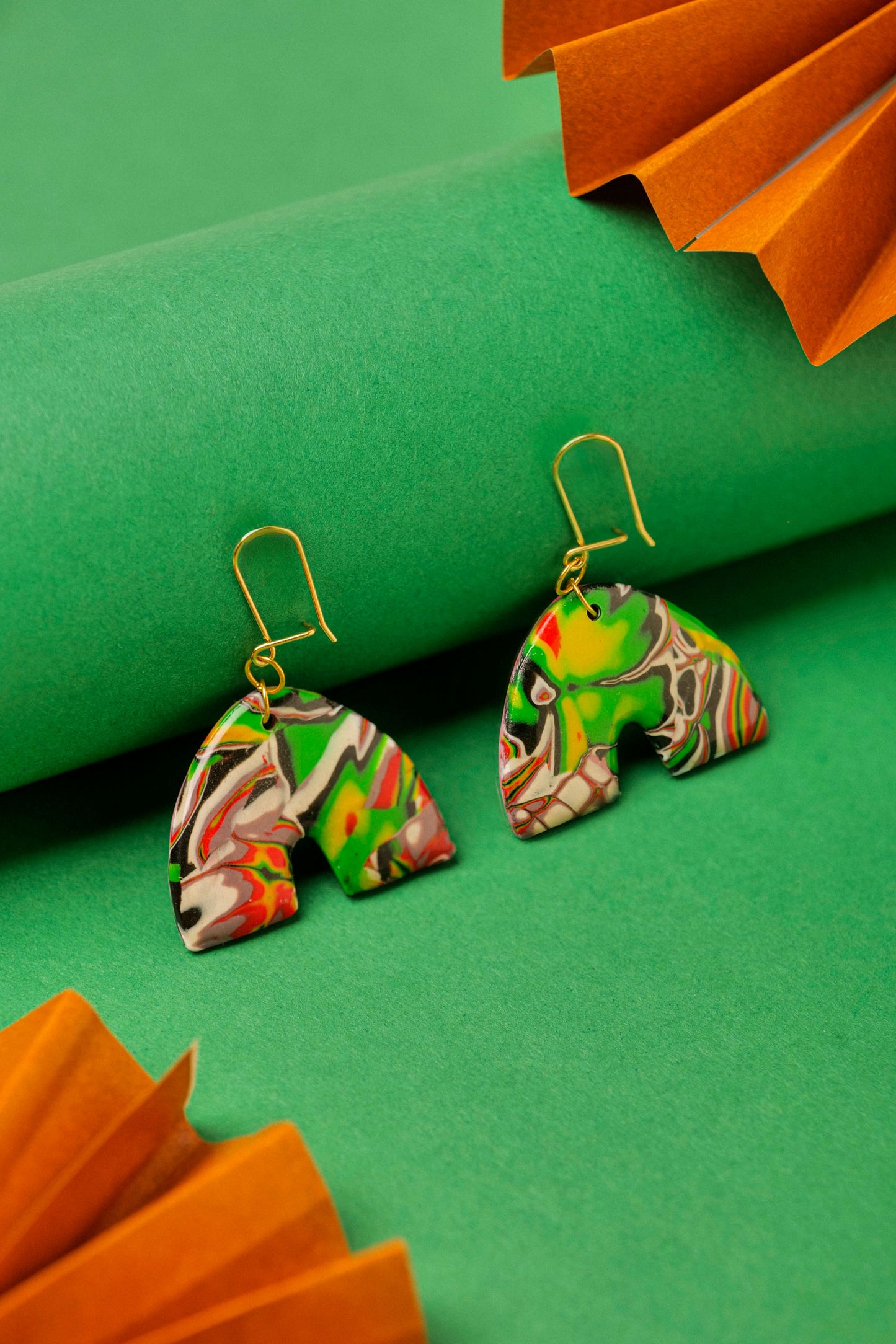 Red, black and green graffiti-style clay arches. Handmade chaos, shaped with care.