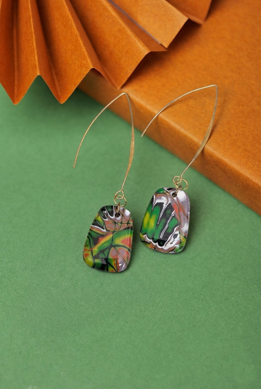 Marbled clay drops in red, green and black with a long gold hook. Lightweight, bold, and handmade in Berlin.