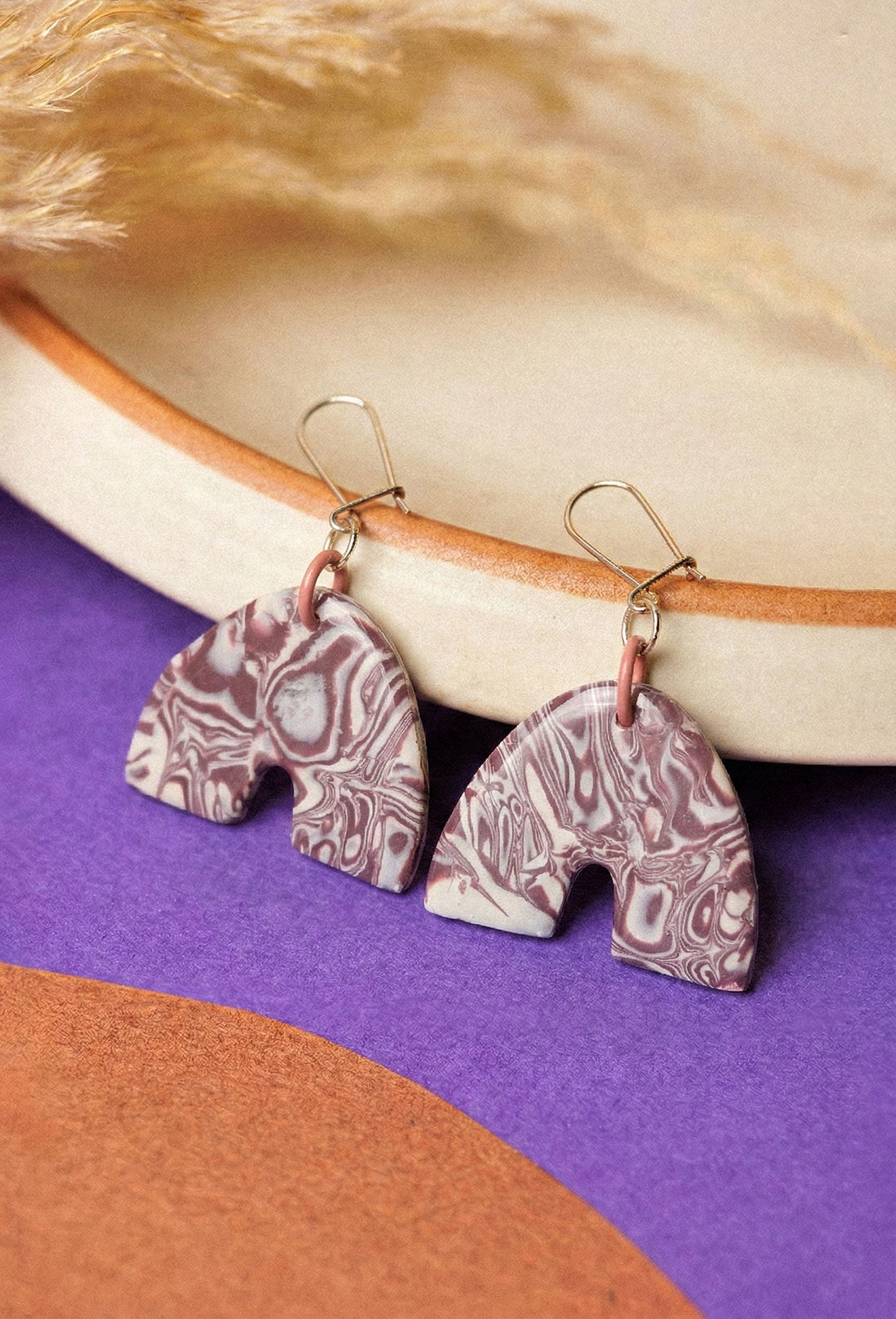 Marbled clay arches in a deep burgundy. Muted drama for everyday outfits.