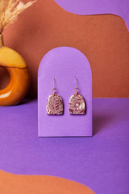Dome earrings in soft burgundy marble. Calm, wearable contrast.