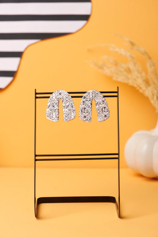 Cat-face line art on white clay. Playful, minimalist, Berlin-weird.