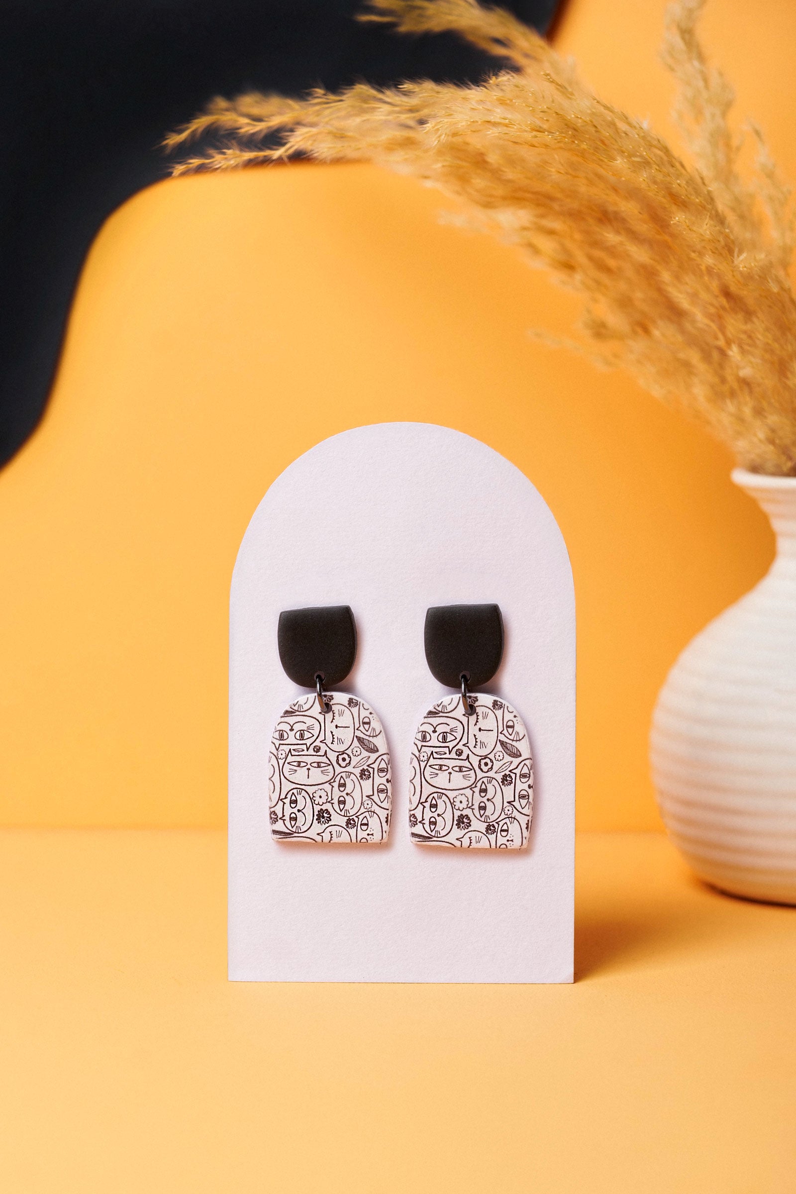 Cat doodle earrings with a bold black stud. A Berlin flea-market kind of cool.