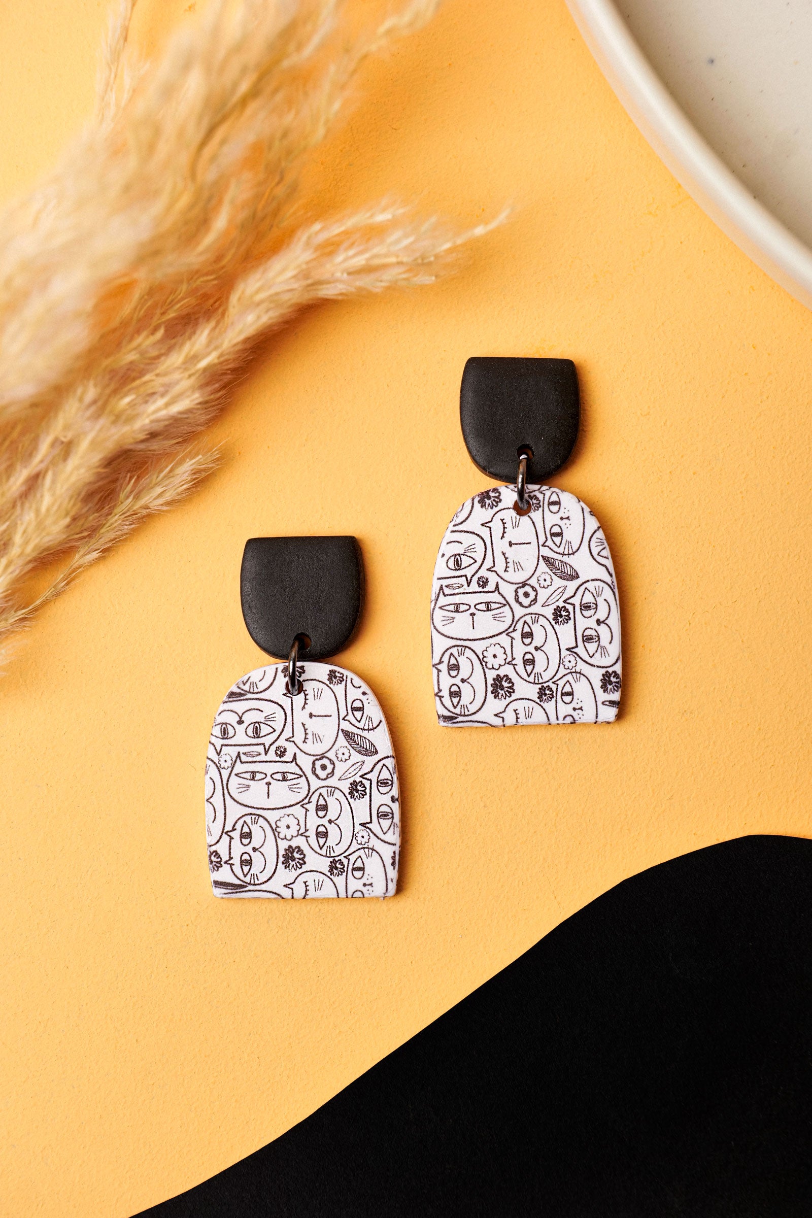 Cat doodle earrings with a bold black stud. A Berlin flea-market kind of cool.