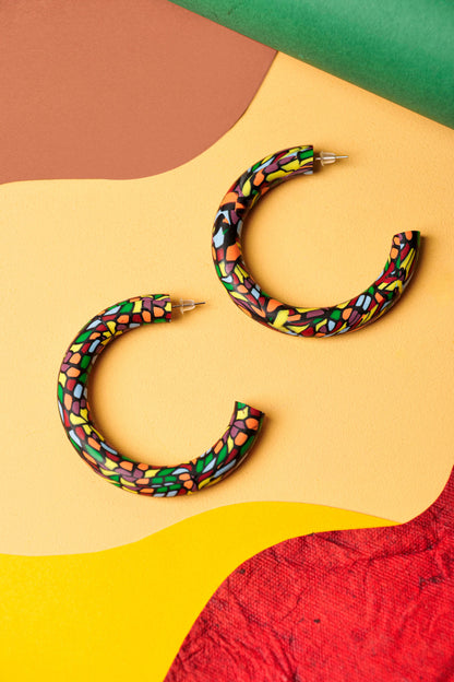 Graphic hoops in black clay with a burst of colour. Bold, lightweight, and handmade in Berlin.