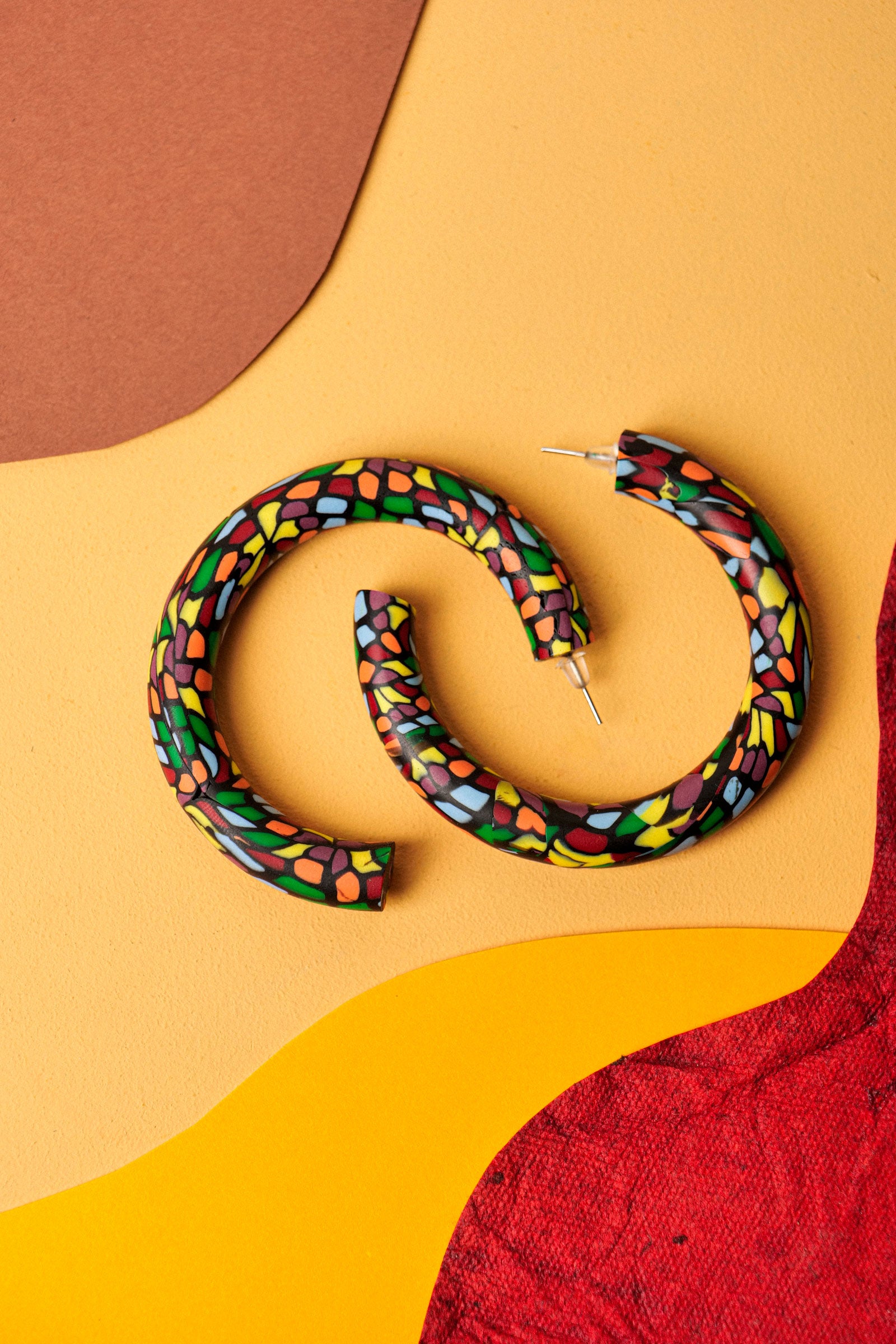 Graphic hoops in black clay with a burst of colour. Bold, lightweight, and handmade in Berlin.