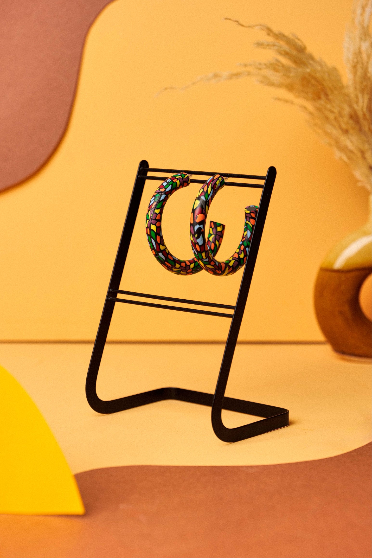 Graphic hoops in black clay with a burst of colour. Bold, lightweight, and handmade in Berlin.