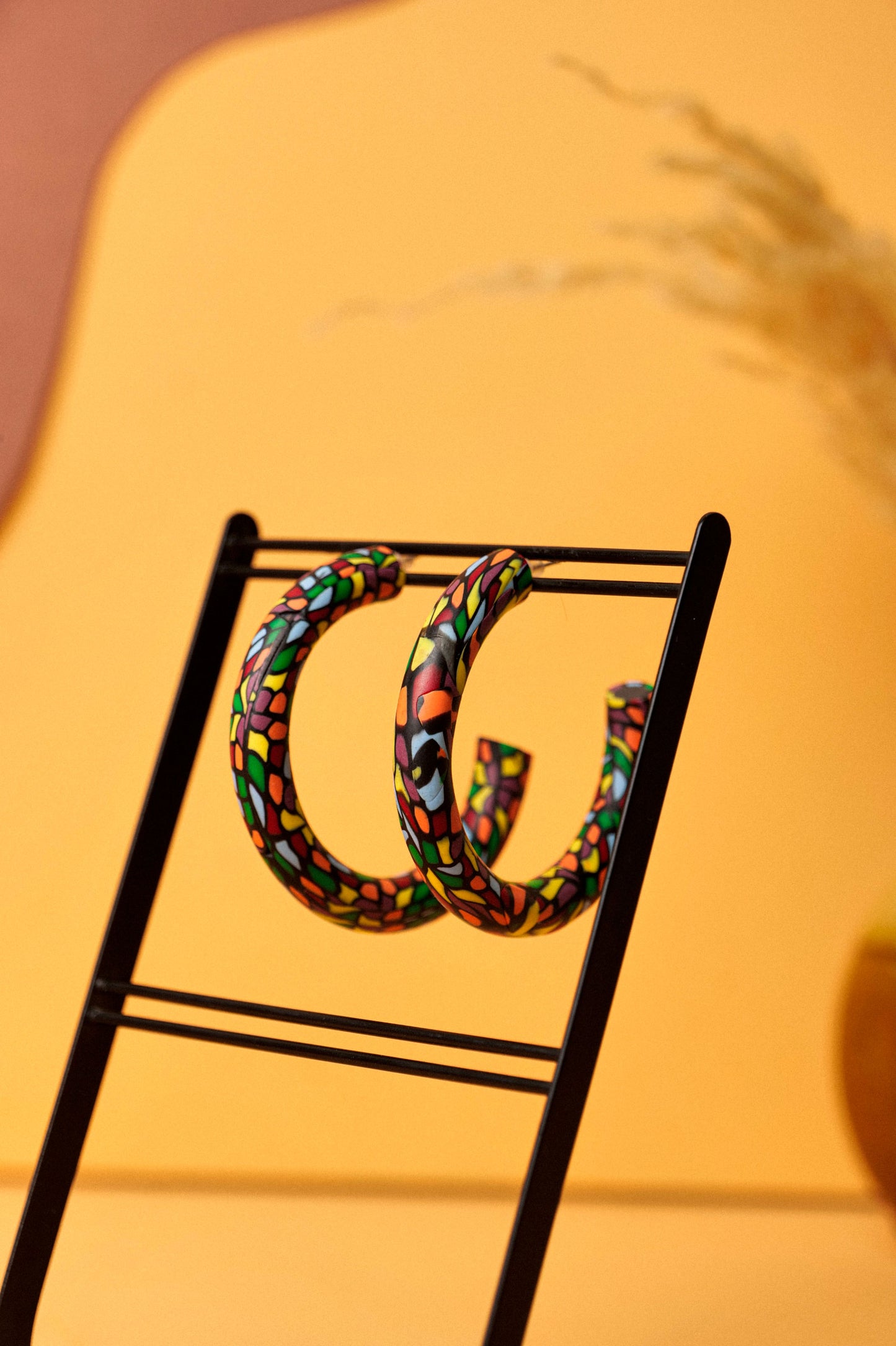 Graphic hoops in black clay with a burst of colour. Bold, lightweight, and handmade in Berlin.
