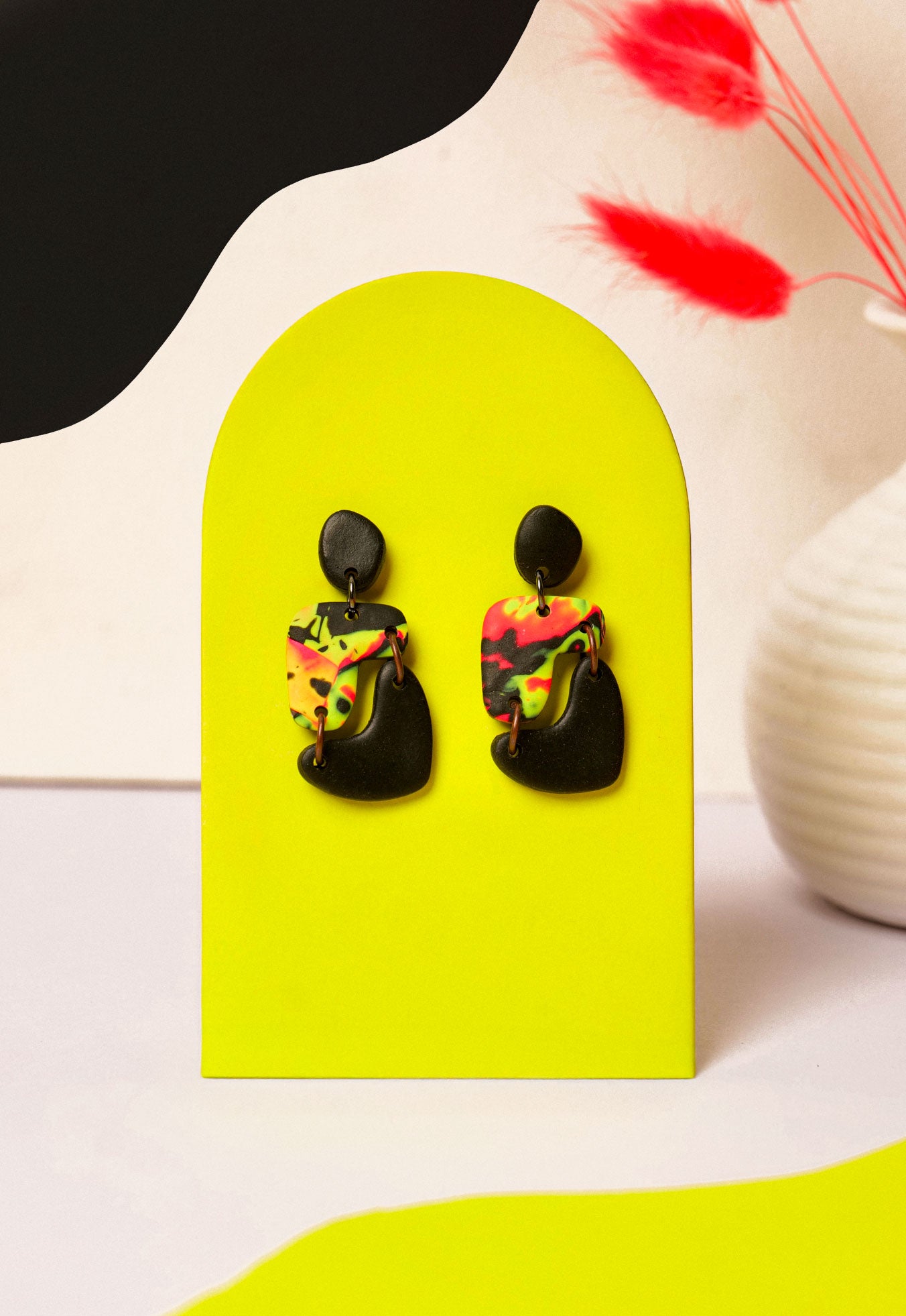 Neon swirl drop earrings in pink, yellow, and black. Like Berlin club nights — loud, layered, and never quite the same.