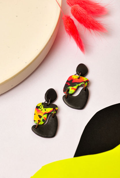 Neon swirl drop earrings in pink, yellow, and black. Like Berlin club nights — loud, layered, and never quite the same.