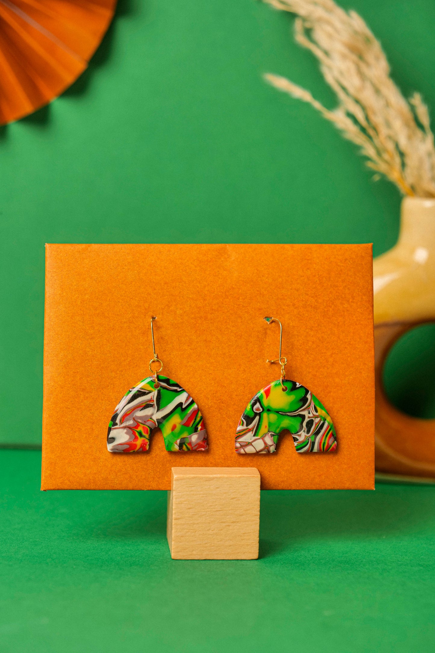 Red, black and green graffiti-style clay arches. Handmade chaos, shaped with care.