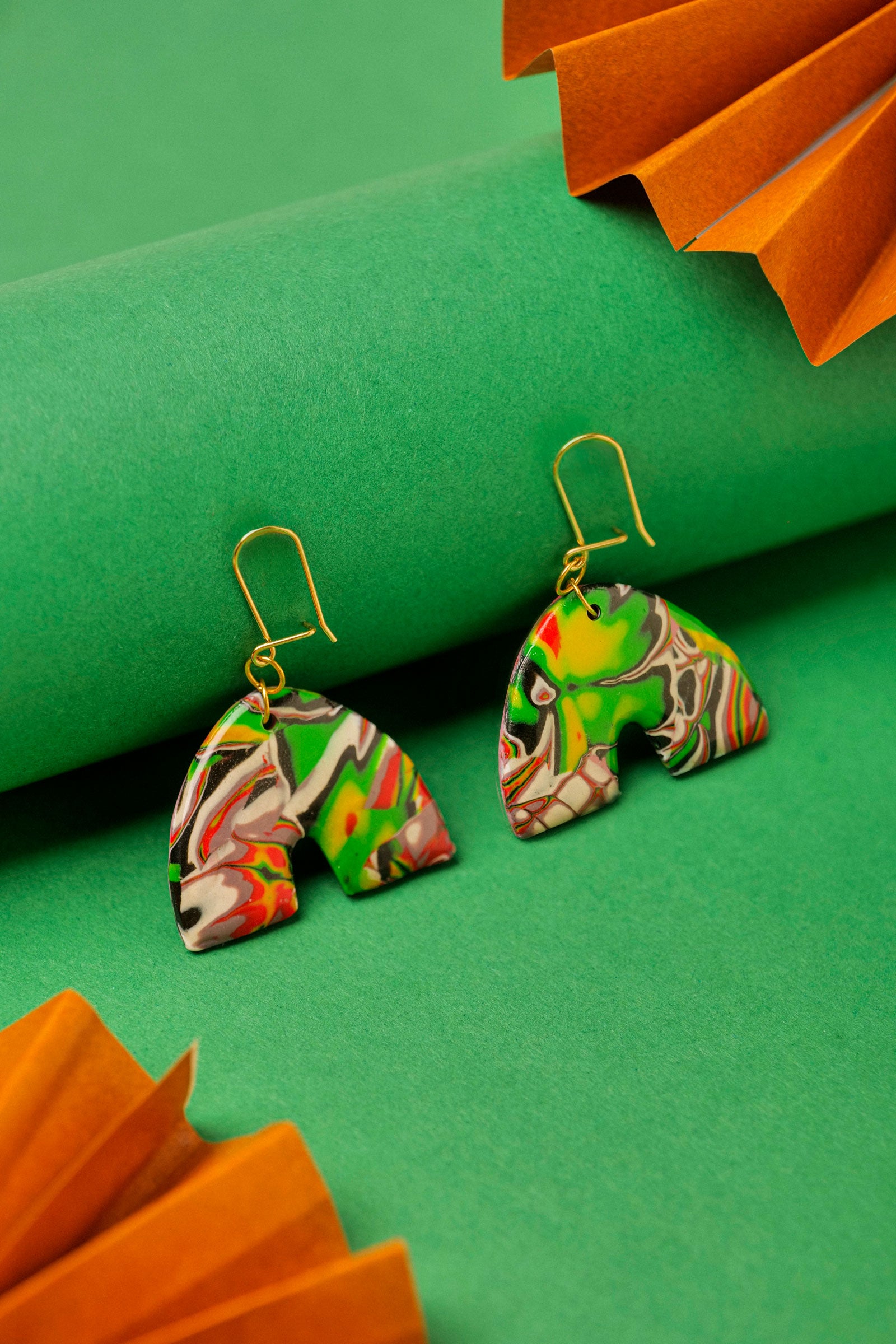 Red, black and green graffiti-style clay arches. Handmade chaos, shaped with care.