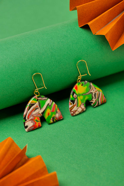 Red, black and green graffiti-style clay arches. Handmade chaos, shaped with care.