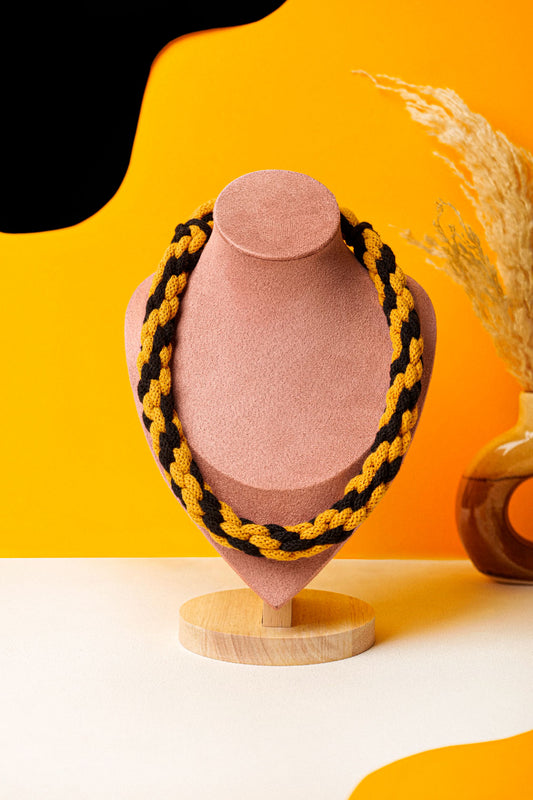Hand-knotted cotton cord necklace in mustard and black. Soft, structured, and bold.